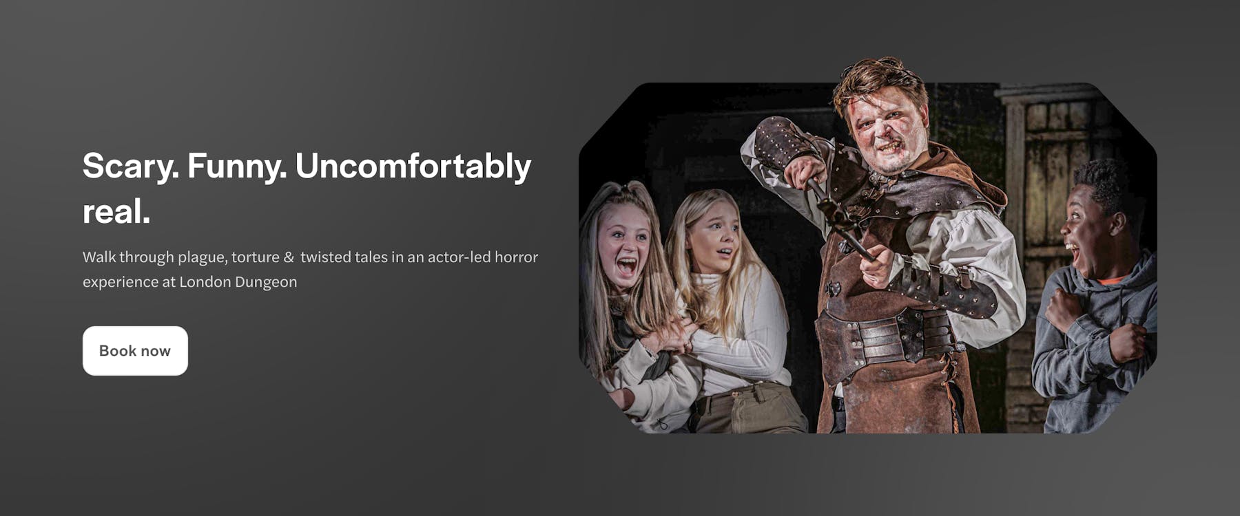 Actor in medieval costume scaring visitors at London Dungeon.